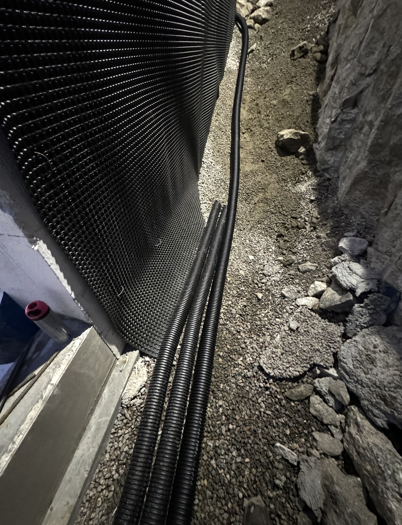 Detalj av knottplast og drensrør langs grunnmur