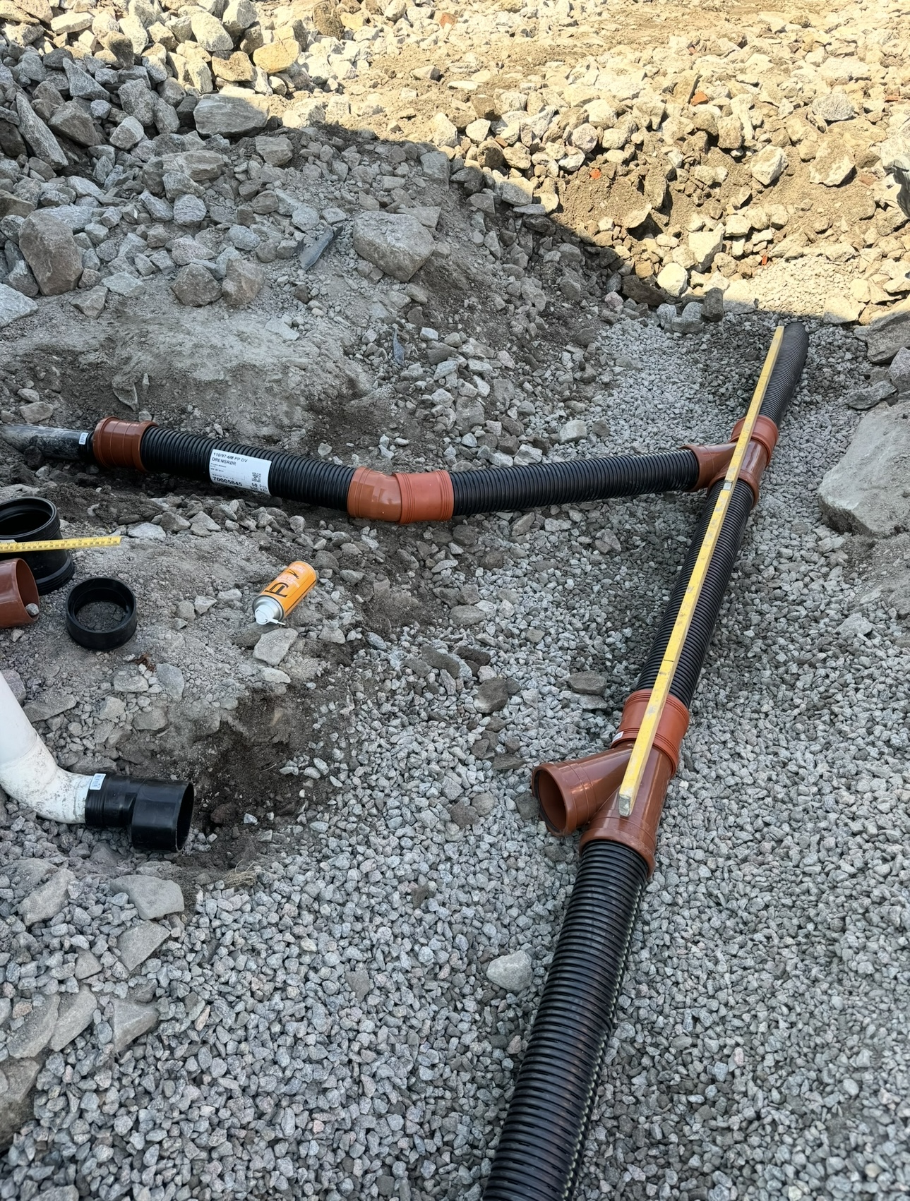 Drensrør og grunnarbeid med pukk og rødbrune koblinger